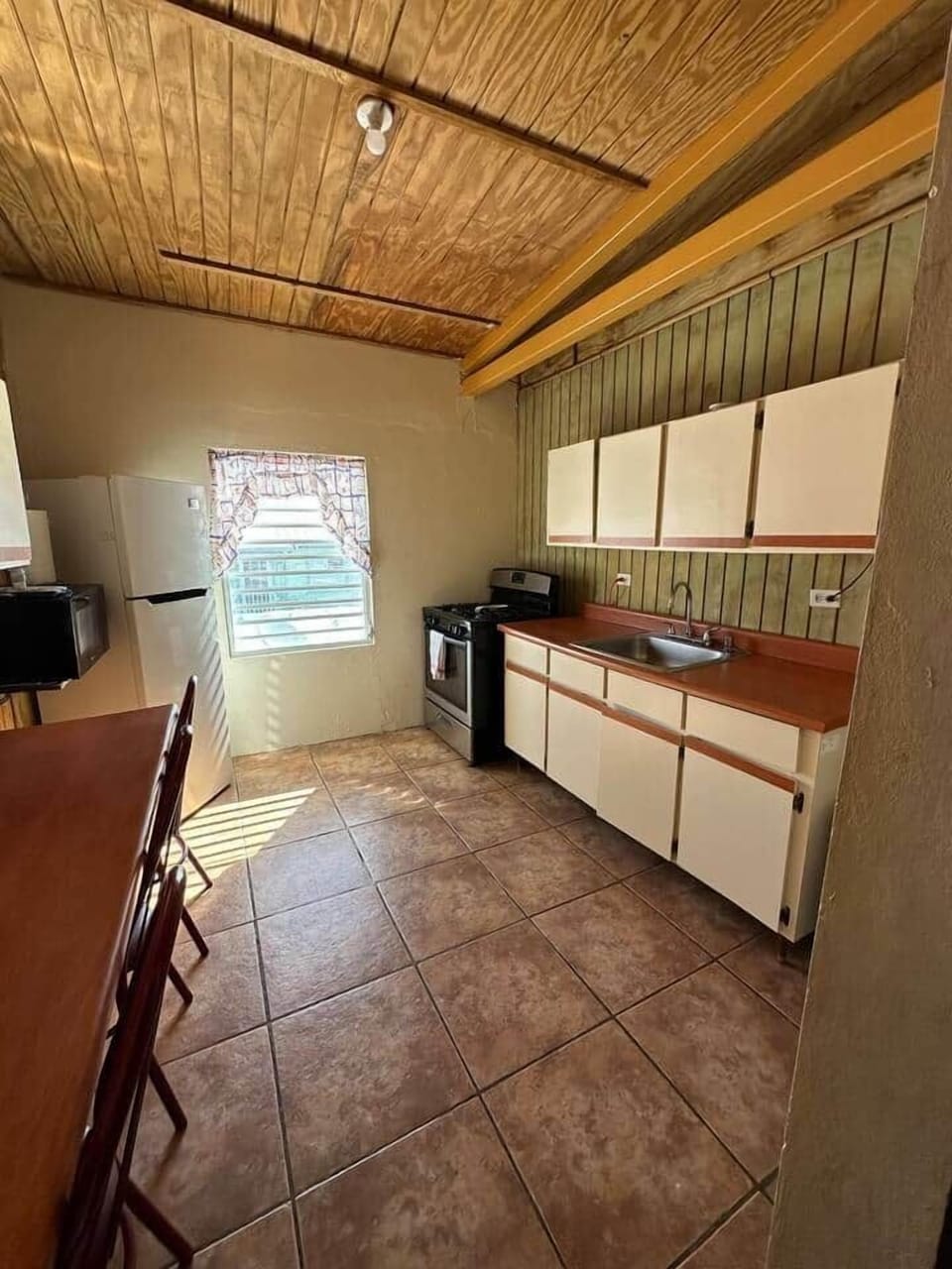 A equipped kitchen with a sitting breakfast area.