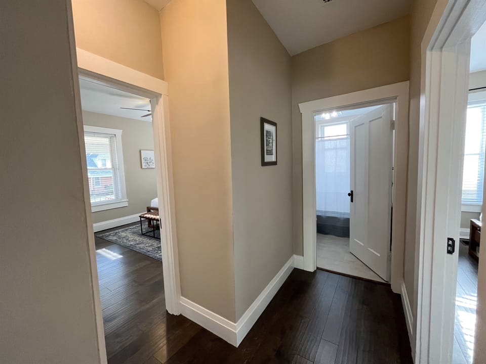 Hallway with bedrooms 1 & 2, bathroom, basement door, and hall closet