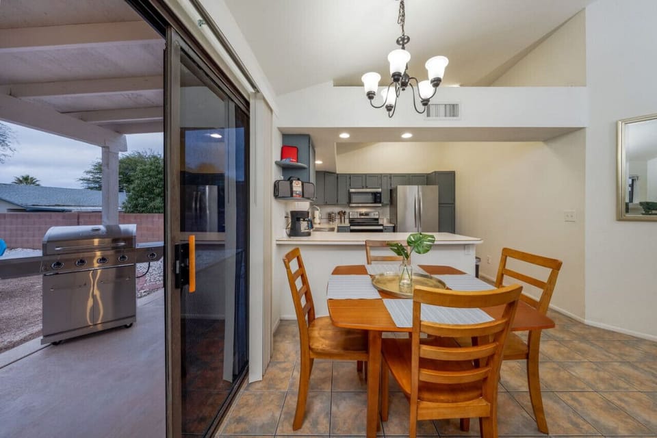 Kitchen area with dining table for 4 and a view of the covered porch and BBQ grill in the backyard