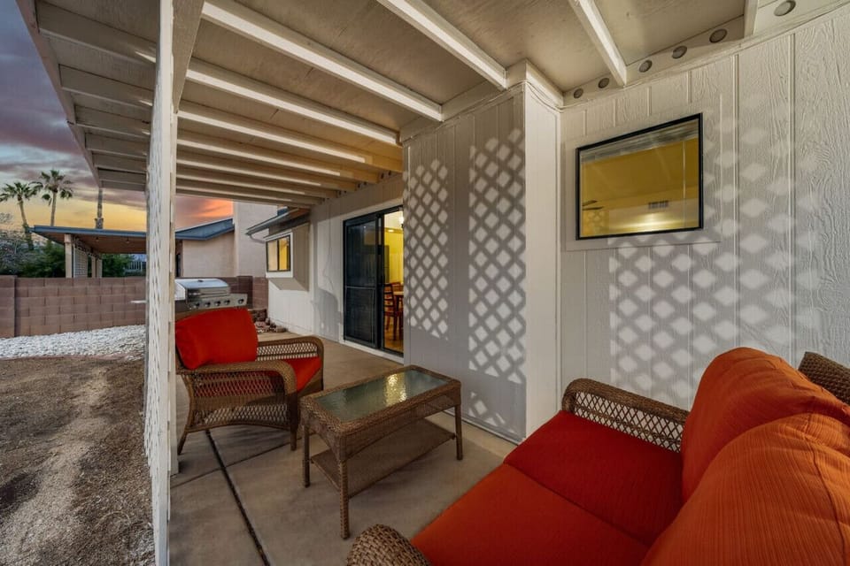 Covered patio with comfortable seating and grill
