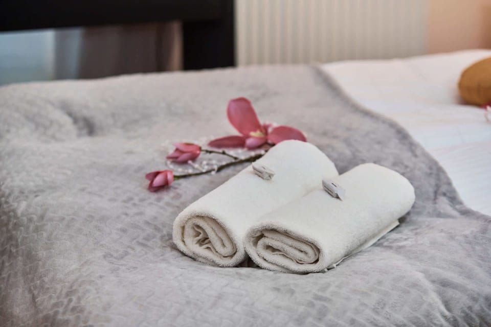 A bedroom with a double bed, decorated with flowers and fresh towels placed at the foot of the bed.