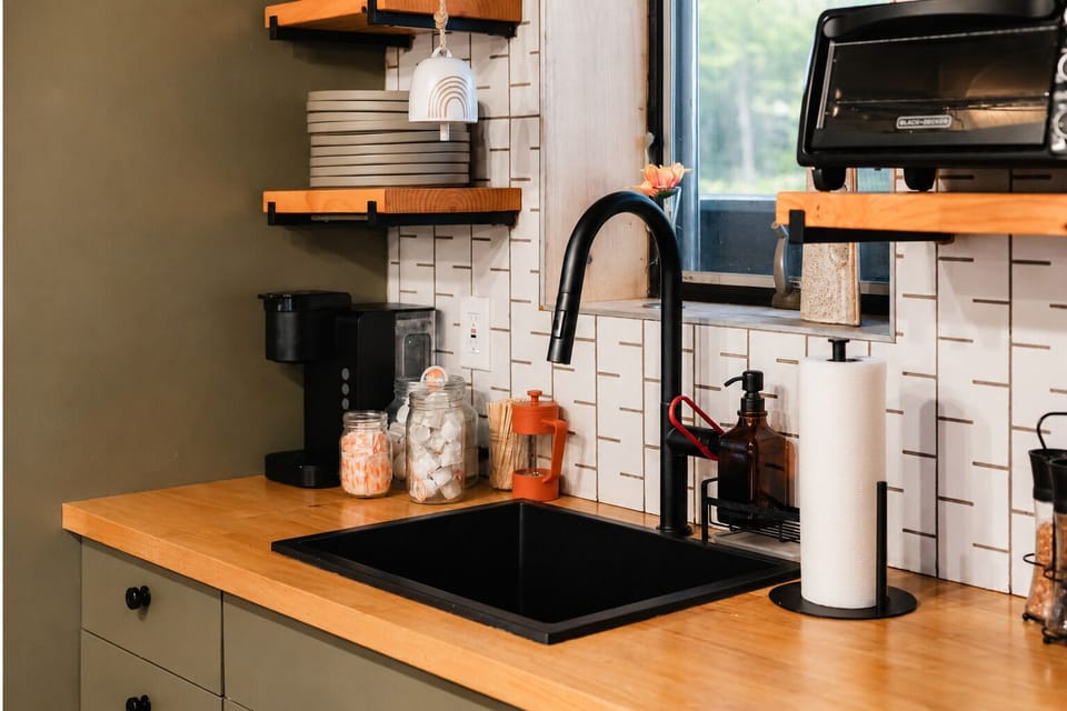 The matte black gooseneck faucet and subway tile backsplash make cleanup easy after a meal; the Keurig coffee machine is ready for your first cup of the morning.