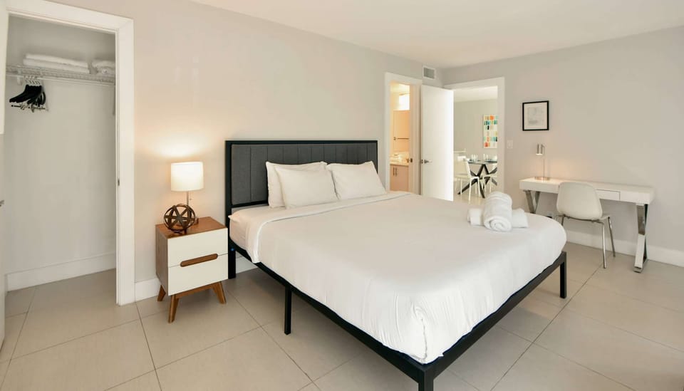 Spacious king bedroom with desk, closet, and open doorway