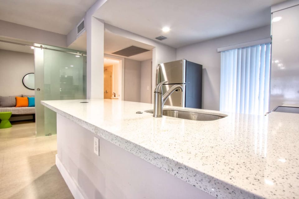 Open kitchen with sink, counter, fridge, and glass wall divider