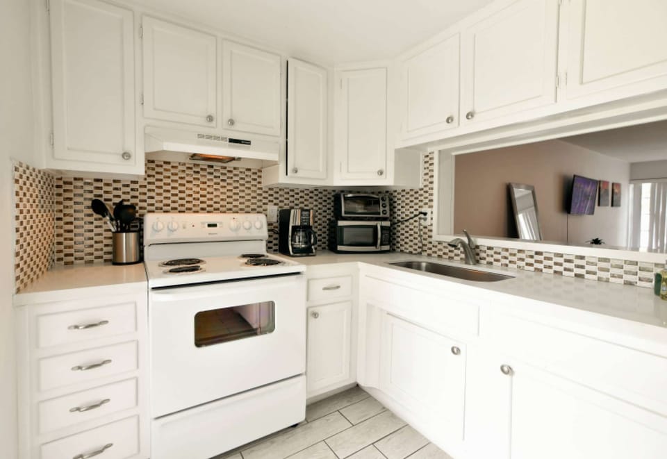 Full kitchen with stove, sink, cabinets, and small appliances