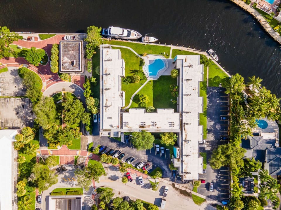 Top view of the property, pool, parking, and water nearby
