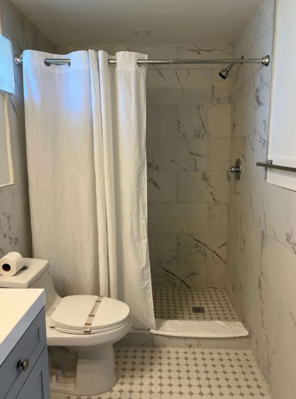 Simple bathroom with shower curtain, toilet, and tiled walls