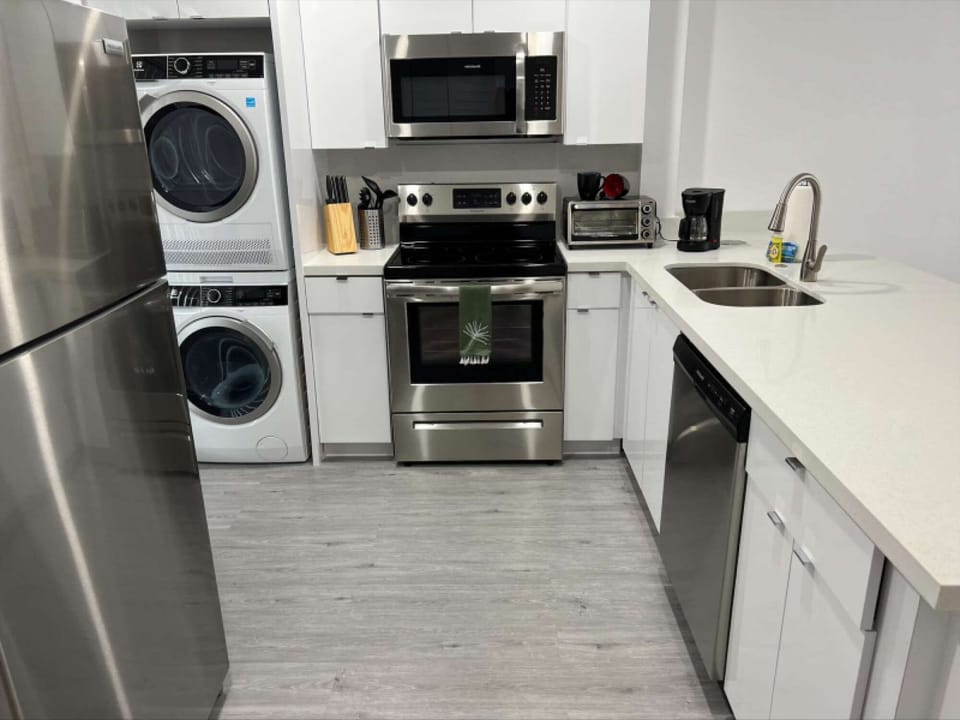 Full kitchen with washer, dryer, stove, sink, and coffee maker