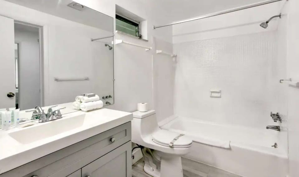 Bathroom with tub shower, sink, mirror, and soft towels