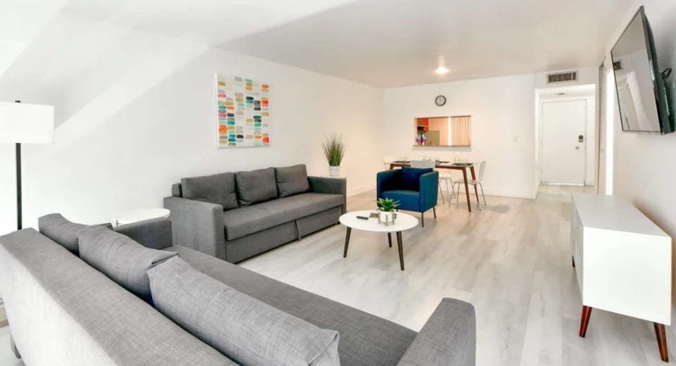 Open living room with sofas, chair, table, and dining area