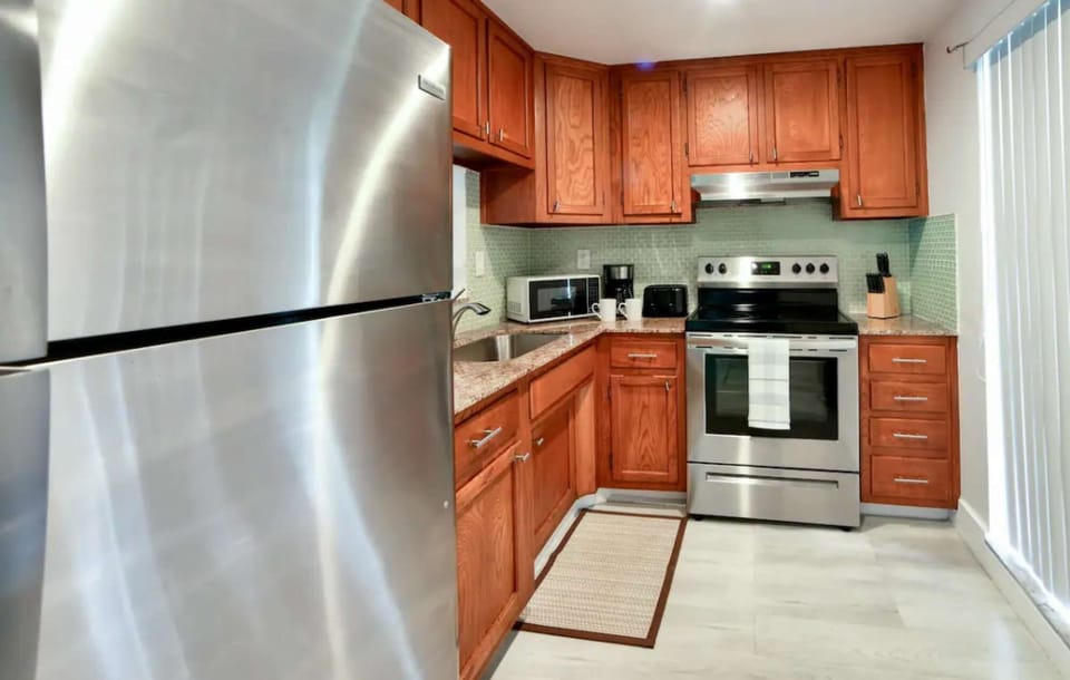 Kitchen with wood cabinets, fridge, stove, and small appliances