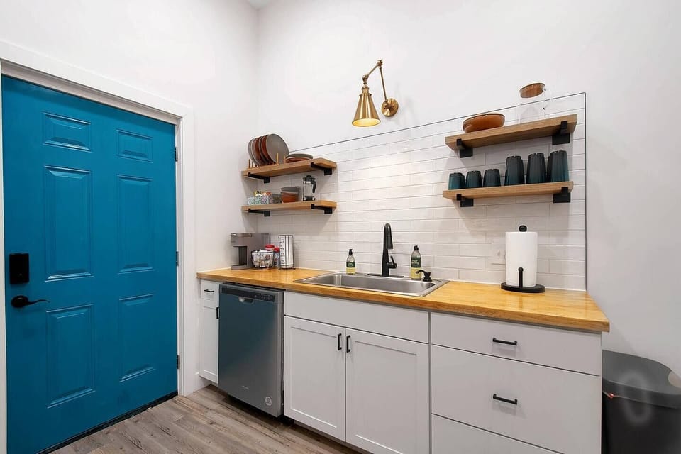 Kitchen with small dining area, butcher block countertop, stainless steel appliances - opens into the laundry room.