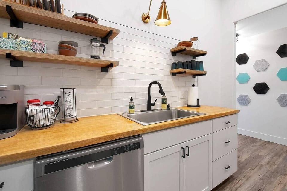 Kitchen with small dining area, butcher block countertop, stainless steel appliances - opens into the laundry room.