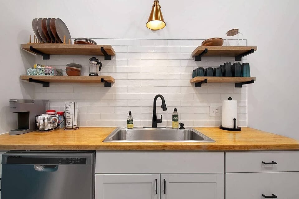 Kitchen with butcher block countertops, backsplash and cute shelving. 