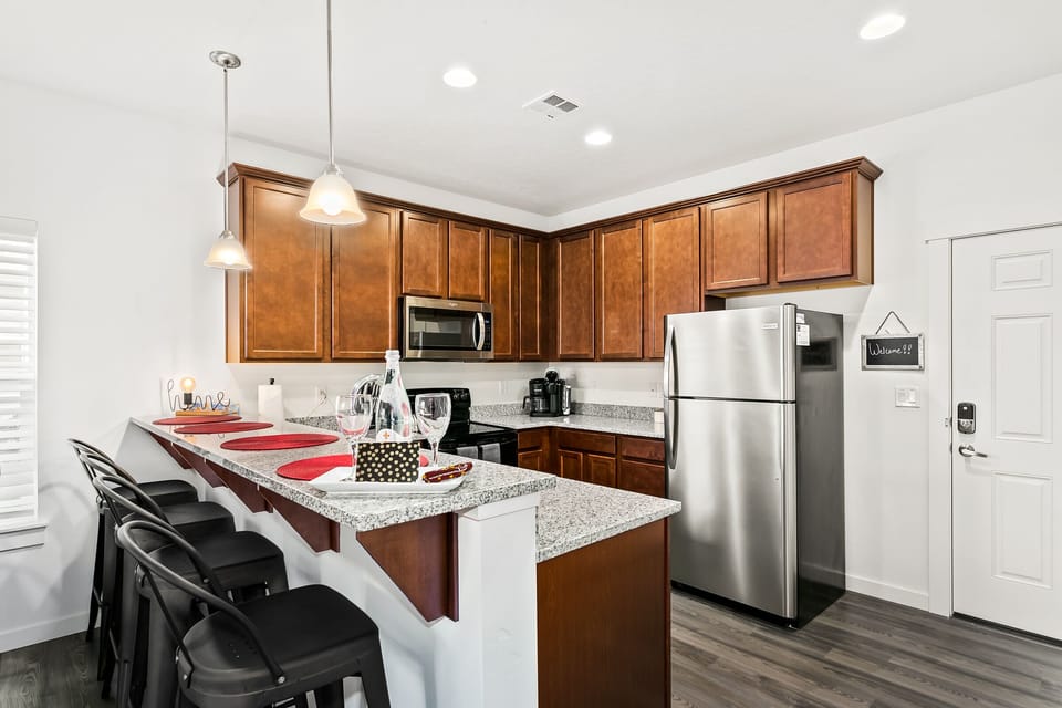 View of kitchen with granite counters and upgraded appliances.