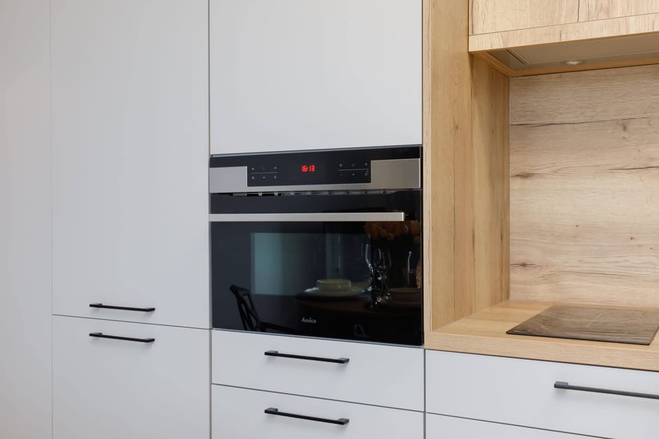 A kitchen with built-in appliances and natural wood accents.
