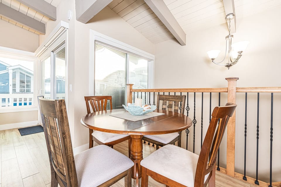 The dining area seats four, with additional seating at the kitchen counter.
                