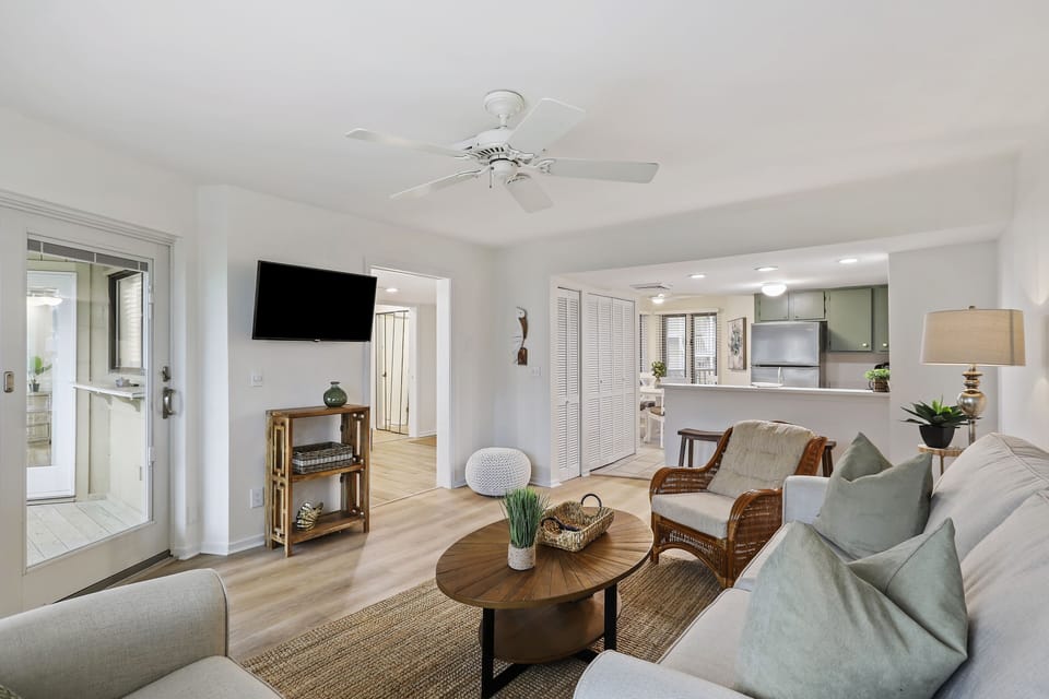 Open living room and kitchen connect to foyer and screened porch.
