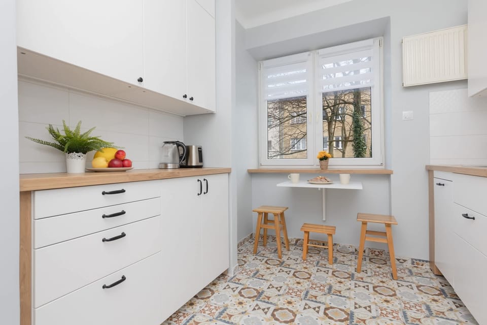 Fully equipped kitchen with white cabinets, ample counter space, and a charming patterned floor.

