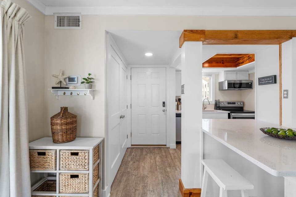 Step into your bright, welcoming space where coastal charm meets modern convenience. Natural wood accents and crisp white finishes create a serene flow from entry to fully-equipped kitchen.
