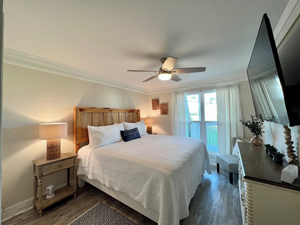 Sink into your plush bed with crisp linens and drift off under the gentle breeze of the ceiling fan in this serene bedroom.