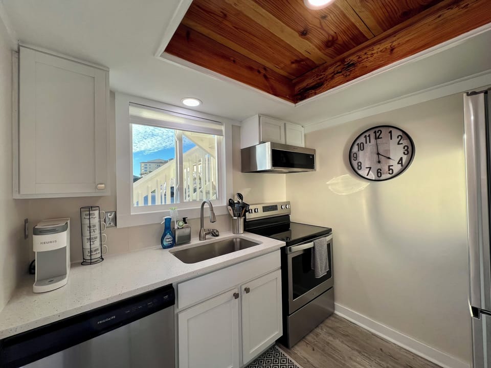 Your fully equipped kitchen features modern appliances and beautiful wood ceiling details, perfect for preparing meals during your stay.