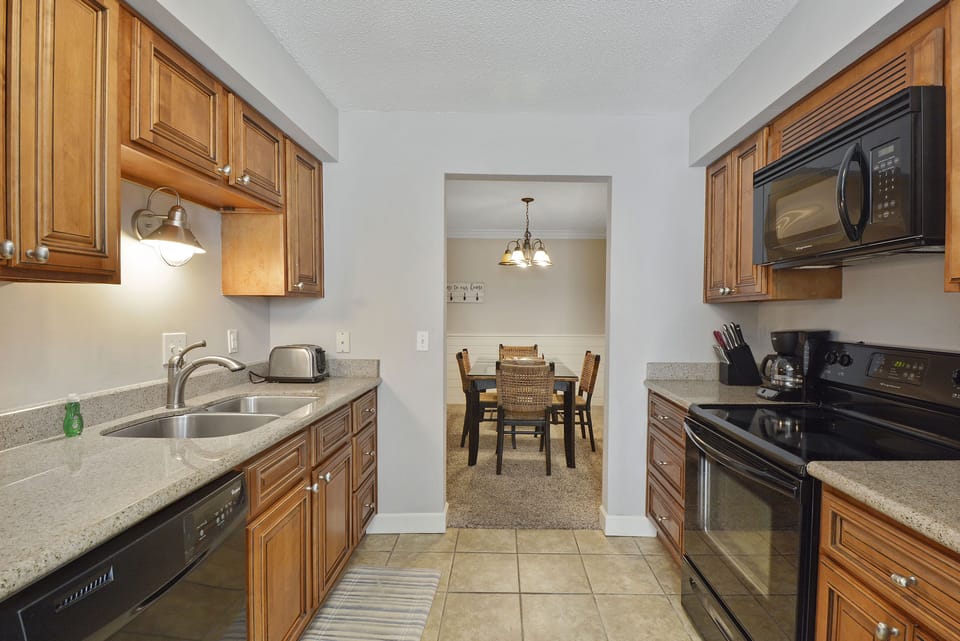 Full Kitchen with Granite Counters - Kitchen with granite counters, full-size appliances, microwave, dishwasher, and dining area nearby.