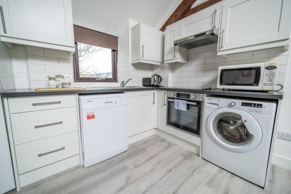 A sleek, fully-integrated kitchen featuring a washer, dishwasher, and all the essentials needed for a stress-free self-catering stay.
