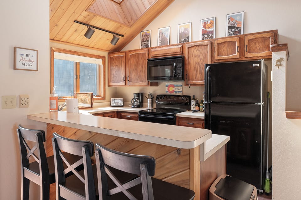 Your cozy kitchen welcomes you with warm wood finishes, a breakfast bar for morning coffee, and everything needed to cook memorable meals.