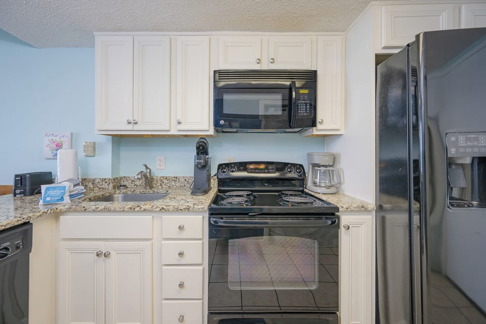 Brew a fresh cup in the kitchen, readying for a relaxing day by the coast with loved ones in this inviting space
