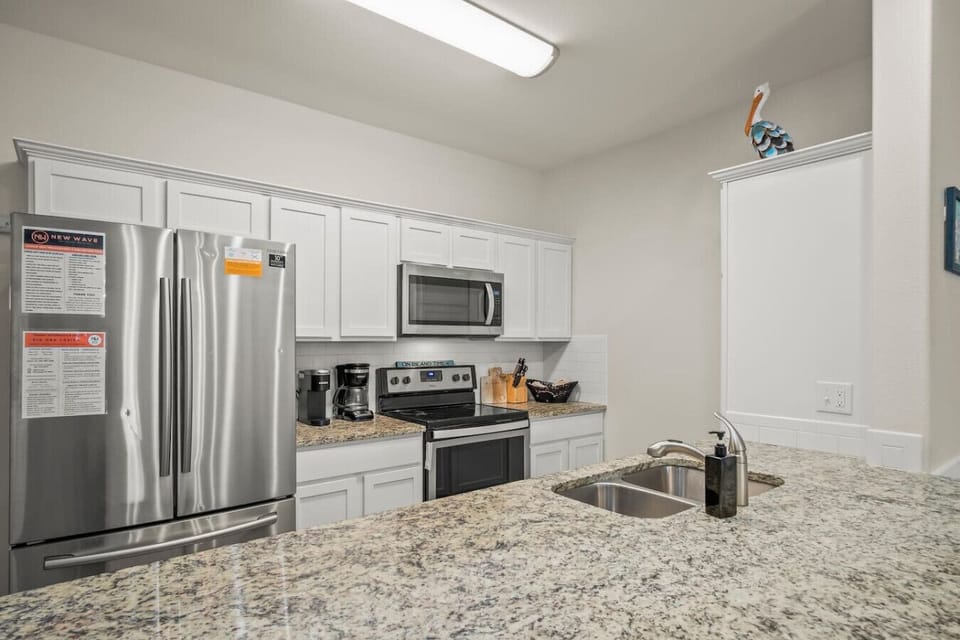 Fully equipped kitchen with stainless steel appliances and granite counters.