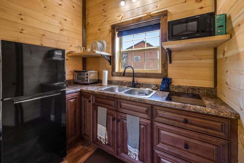 Cozy kitchen with fridge, microwave and toaster oven.