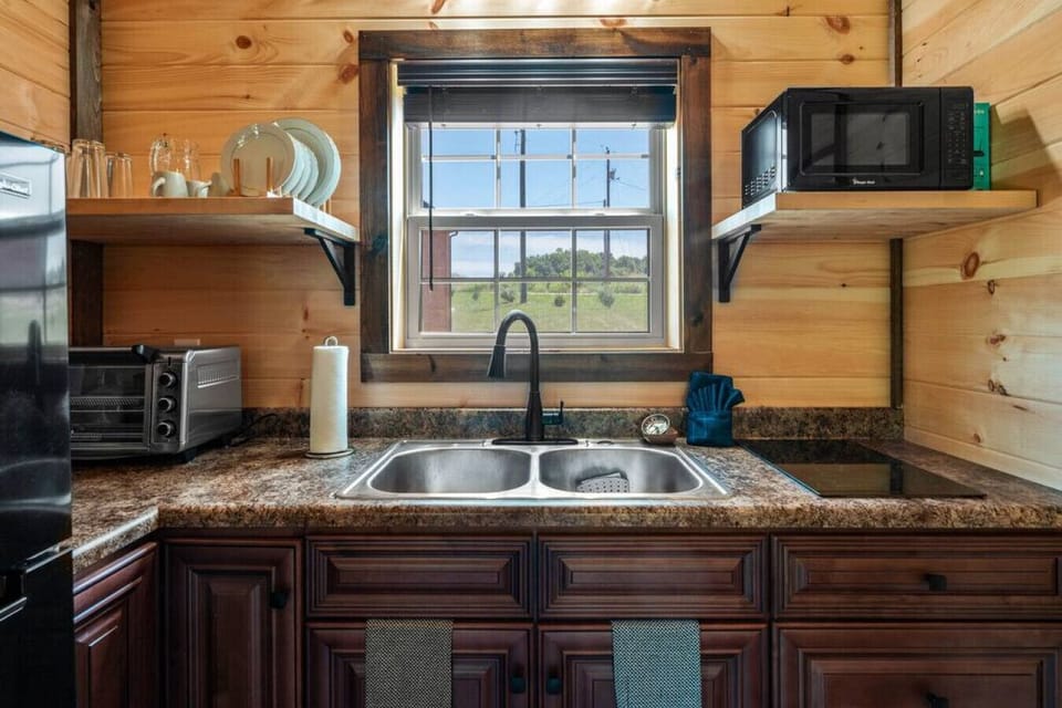 Cozy kitchen with fridge, microwave and toaster oven.