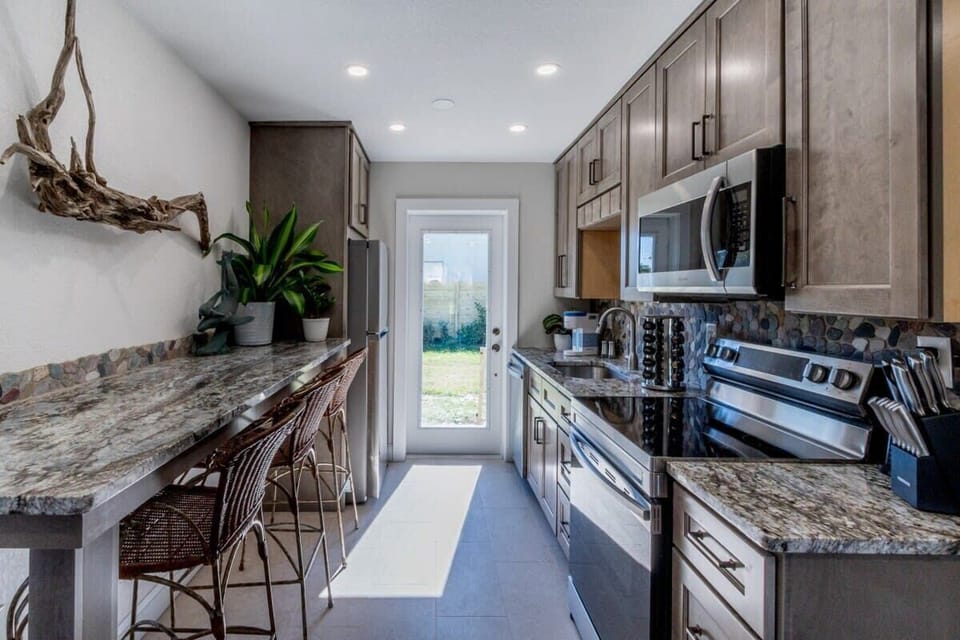 Modern kitchen with granite countertops and stainless steel appliances.