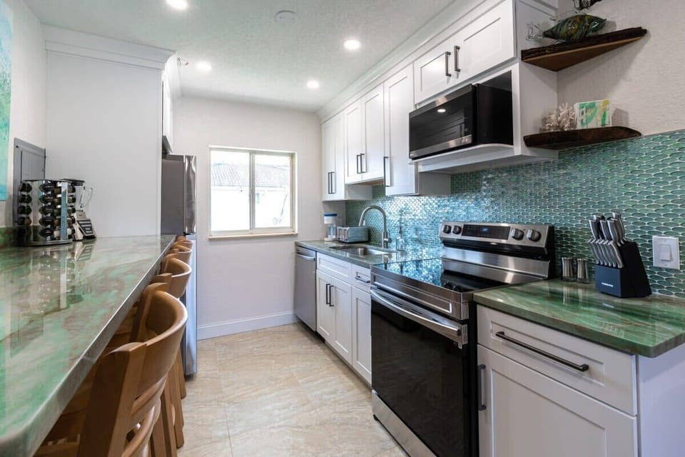 Modern kitchen with green countertops and a teal tile backsplash