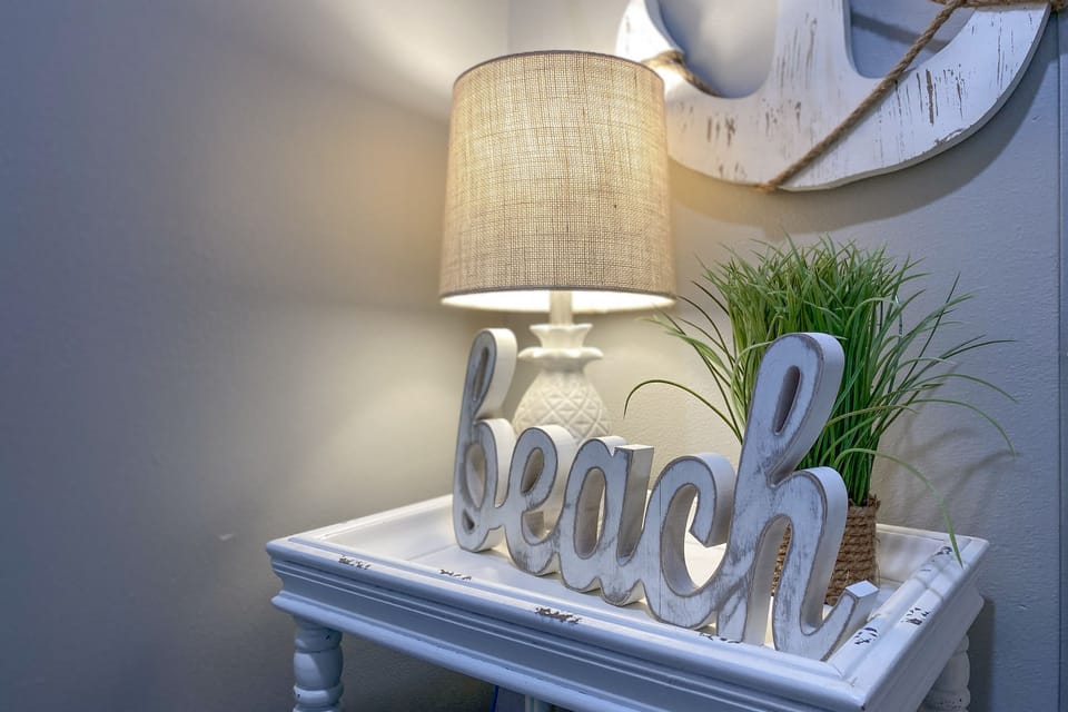 The soft hues of the beach-themed artworks complement the serene and inviting atmosphere of the interior space.