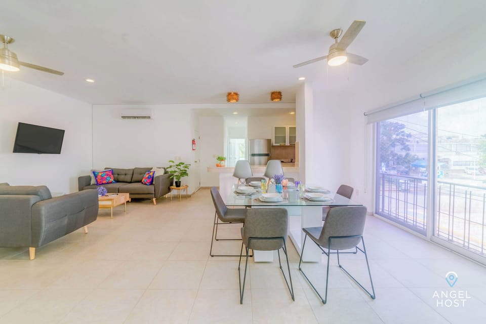 Stylish glass dining table with 6 comfortable chairs near the floor-to-ceiling sliding doors