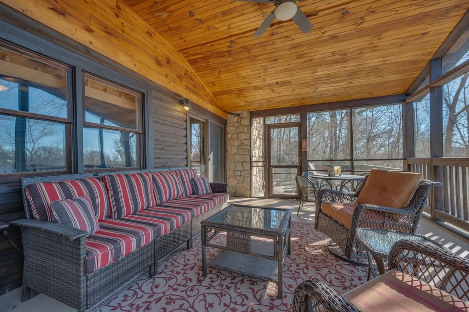 Main level deck of the cabin with plenty of seating and a screened in porch
