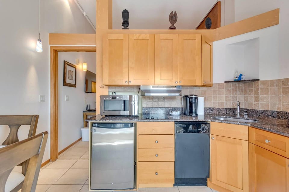 Enjoy the convenience of a fully equipped kitchen, featuring microwave, coffee maker, dishwasher, cooktop, dish ware and utensils.