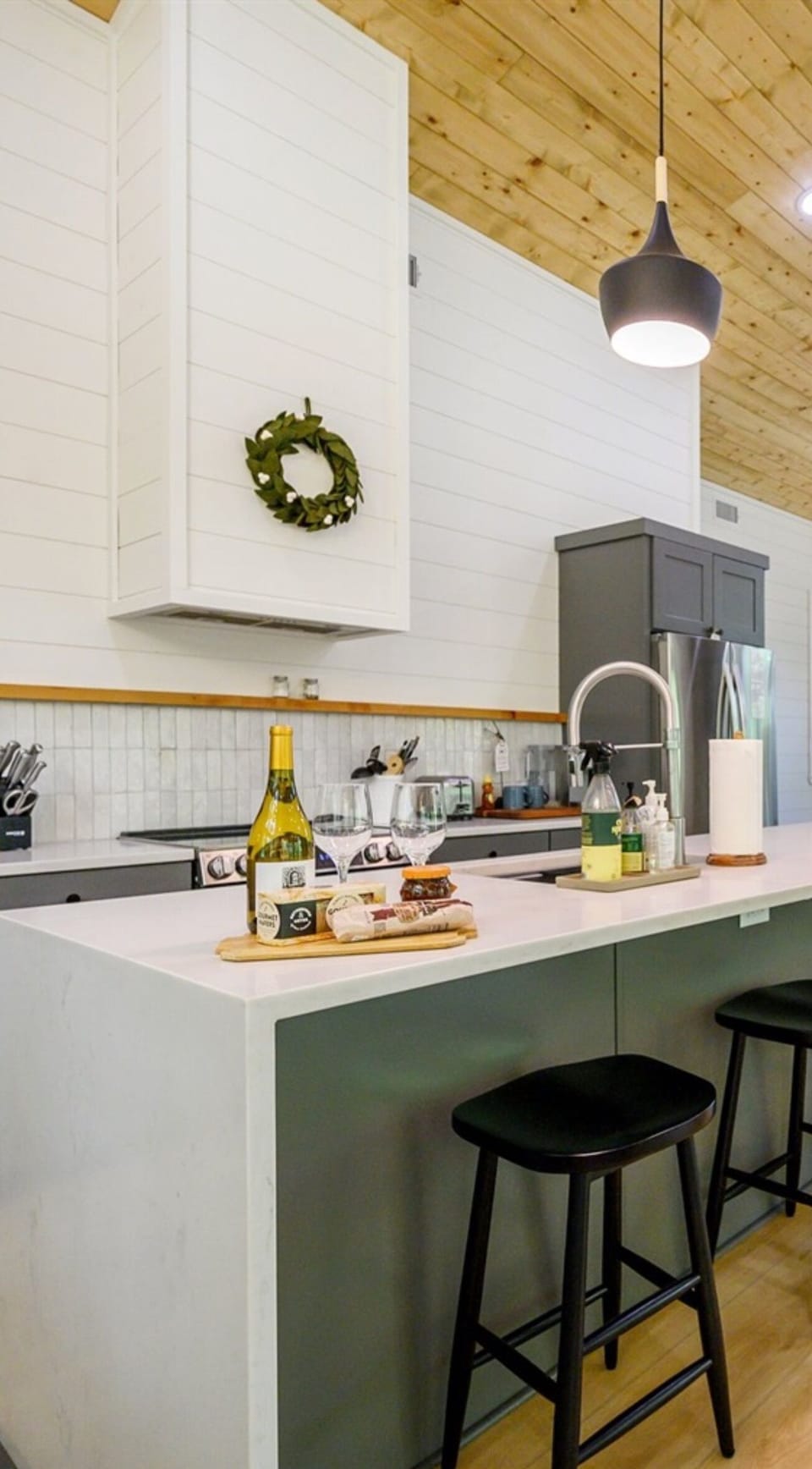 "Transform meal prep into a stylish affair in this kitchen featuring a rustic wood ceiling that adds warmth to the modern bar stools."