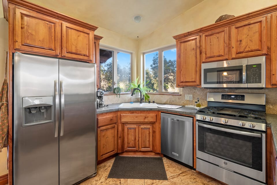 Gather by the windows with stainless appliances and warm wood cabinets