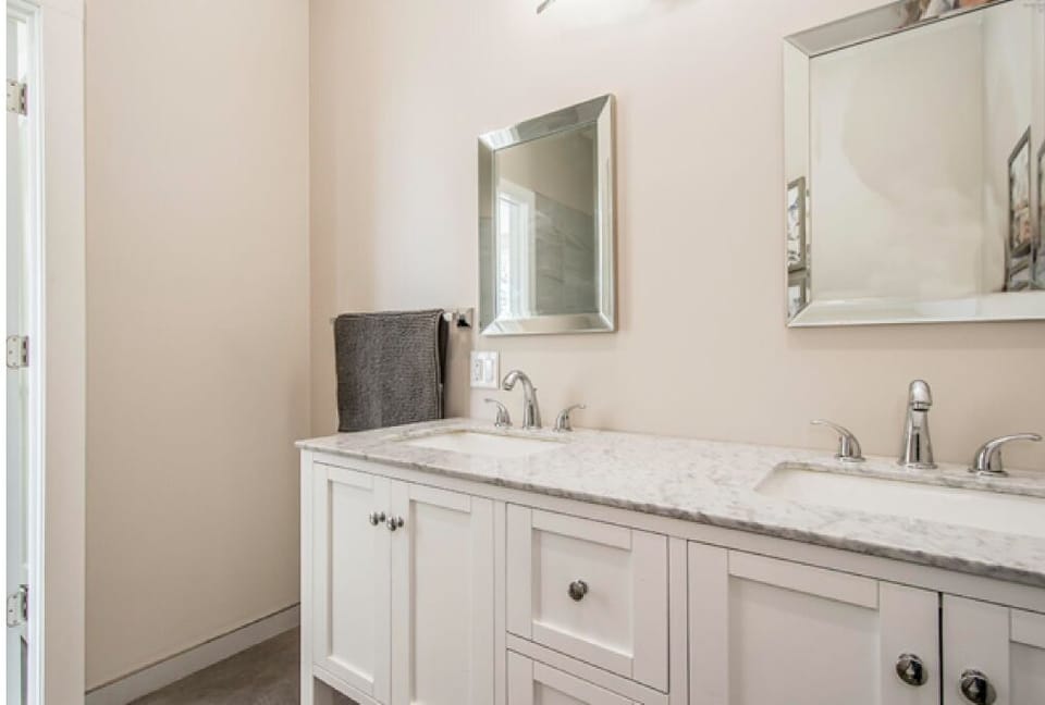 Main bedroom bathroom with shower, double sink and toilet