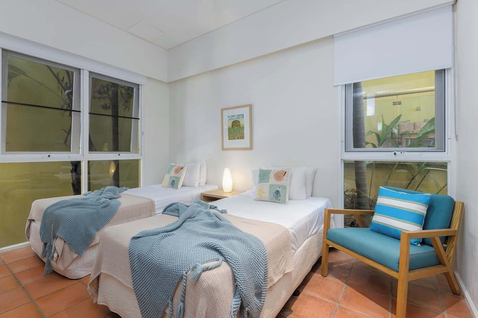 Light-filled guest bedroom with twin bedding configuration
