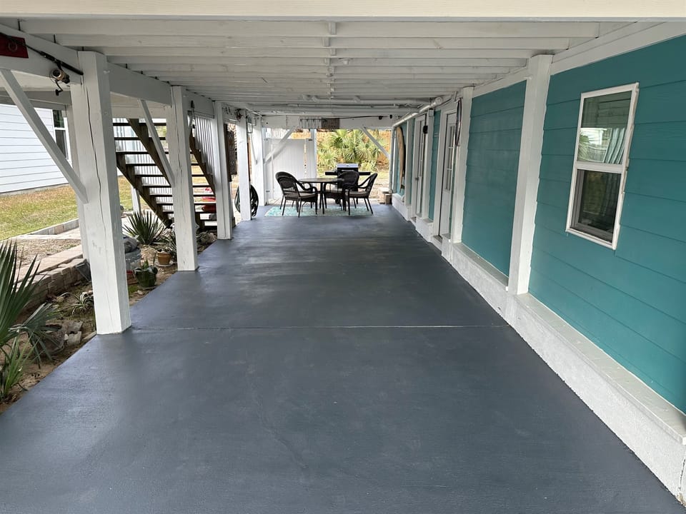 Downstairs patio where there are outdoor games like cornhole, paddle ball, spikeball.