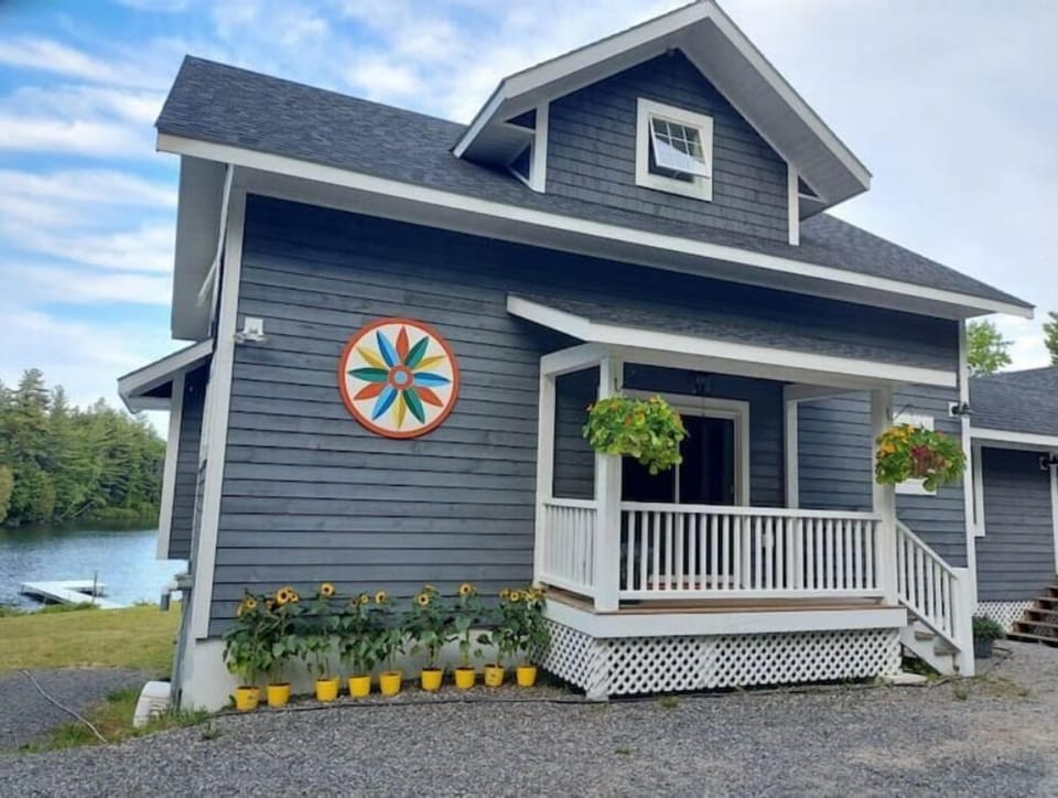 Front of house in summer, abundant flowers with plenty of parking out front.
