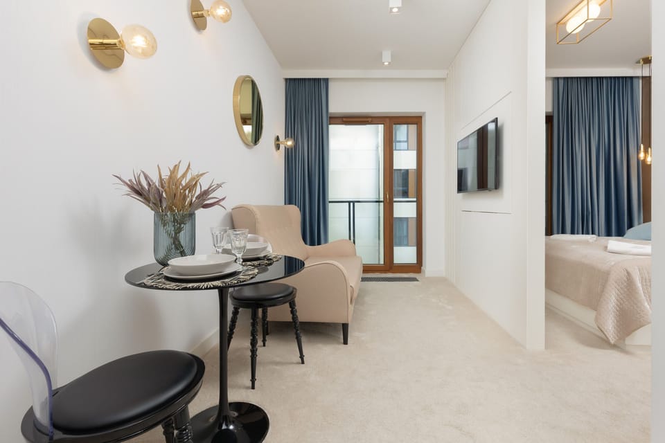 A stylish dining area with a table for two, complemented by chic decor and gold wall accents.

