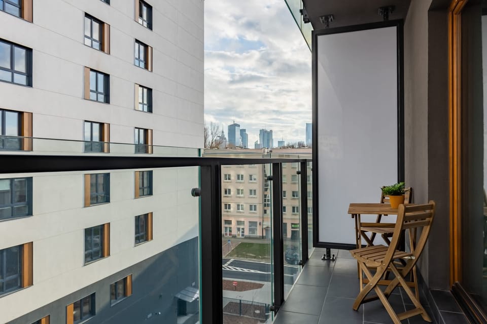 A private balcony with a cozy seating area, offering a peaceful view of the city.

