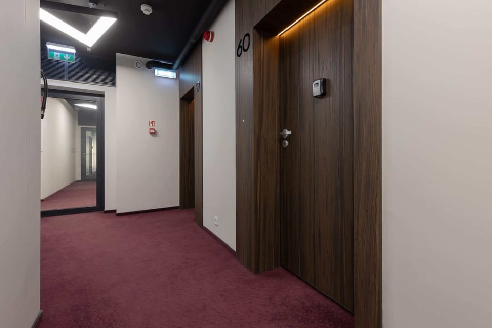 A hallway with stylish flooring and modern finishes, leading to the apartment units.

