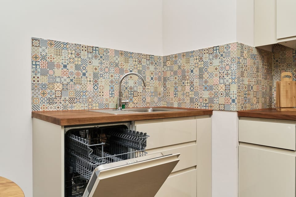 Vibrant kitchen backsplash with colorful patterns, complementing the modern appliances.

