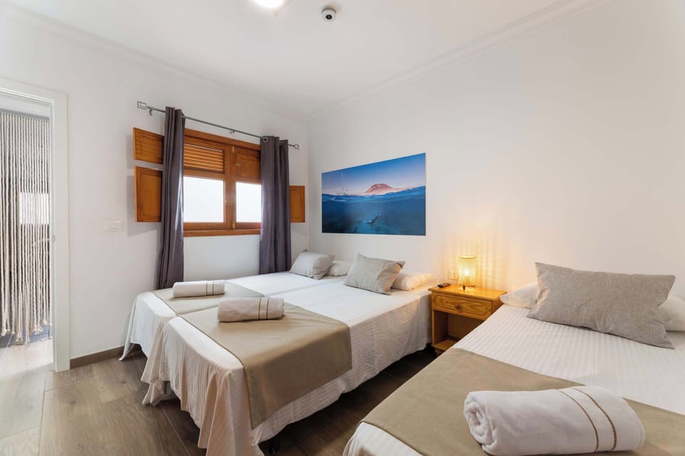 🌅 Despierta con la luz suave de La Graciosa en La Graciosita Coastal Escape by Bayside. 💤 Una habitación acogedora con tres camas, perfecta para familias o amigos que buscan descanso, calma y conexión con la esencia isleña. 🌴